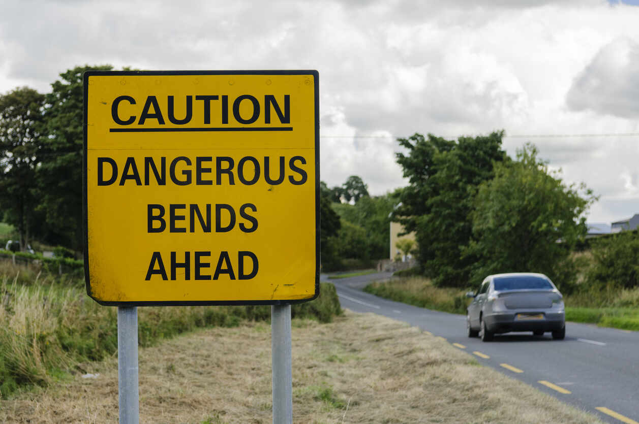 Caution board of dangerous bends ahead